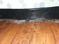 At bottom of bed in floor ...dirt, seven dust, sand?