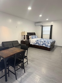 Queen bed with drawers, sofa bed and dining table for four.