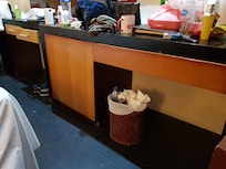 The trash bin is old and rusty. The furniture fixtures are old