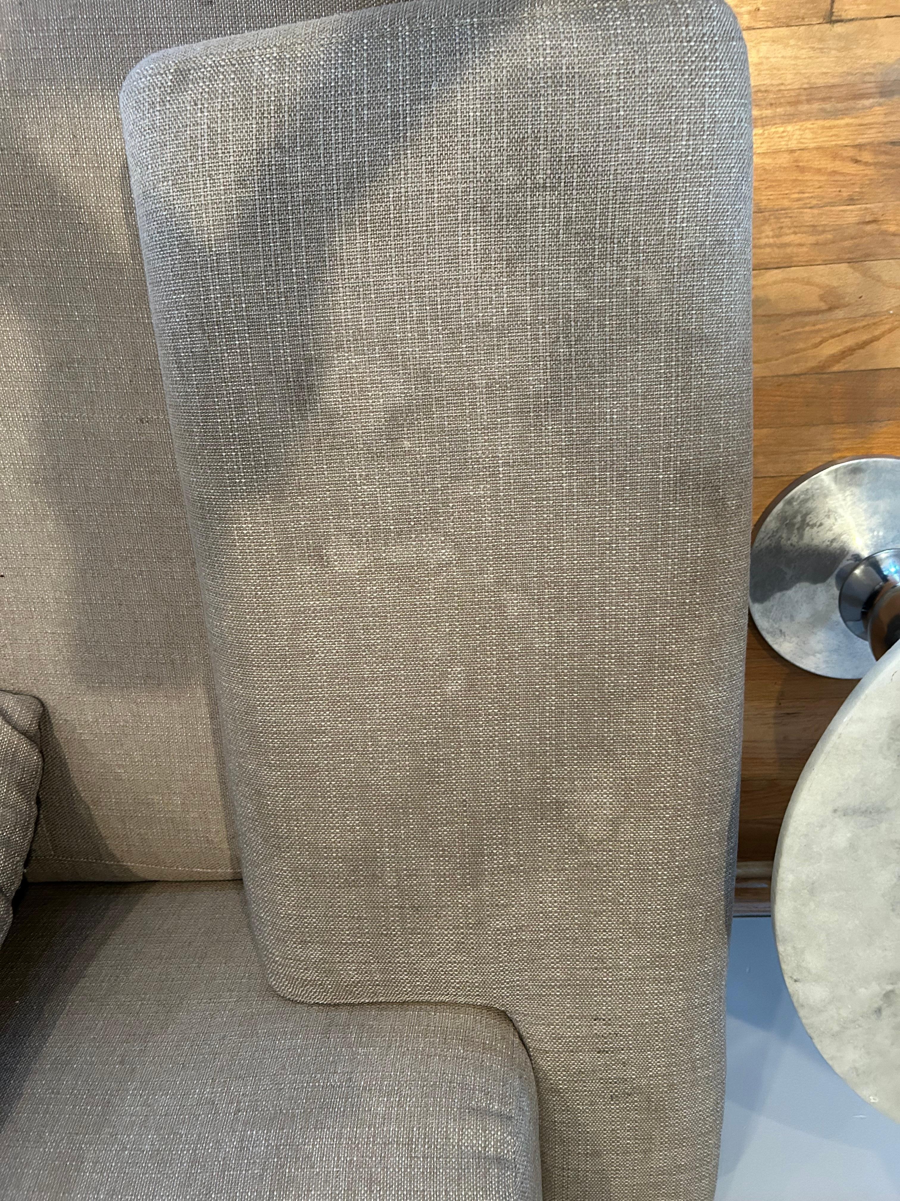 Arm of grey living room couch. Stained and dirty. All couches had stains.
