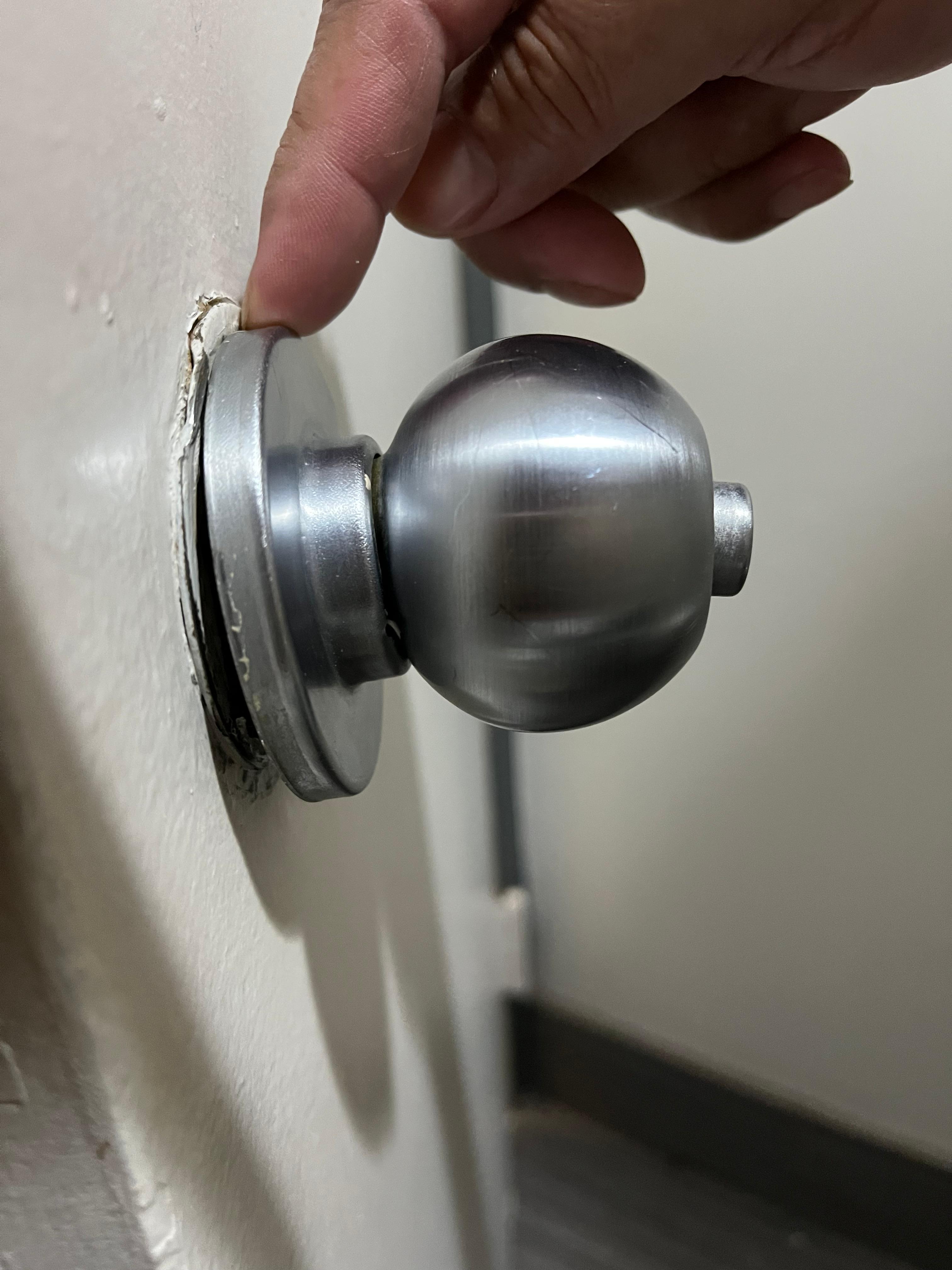 Restroom door knob loose, not easy to close.