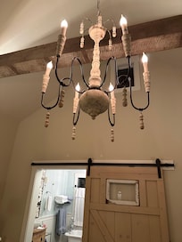 Chandelier, sliding barn door, and claw foot tub!
