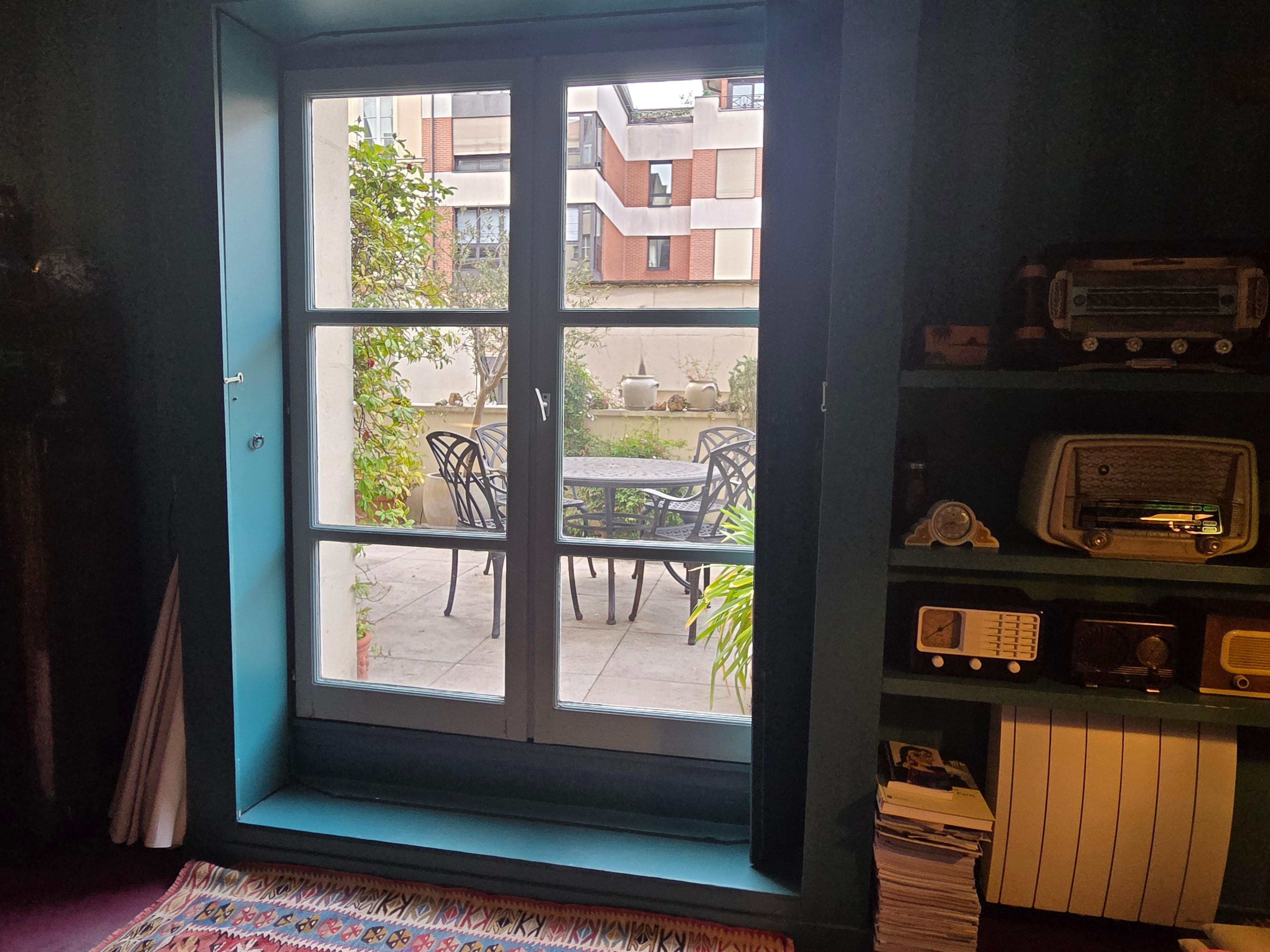Doors to the outdoor patio with table, chairs, blooming jasmine and roses and many other plants. Quiet and relaxing.