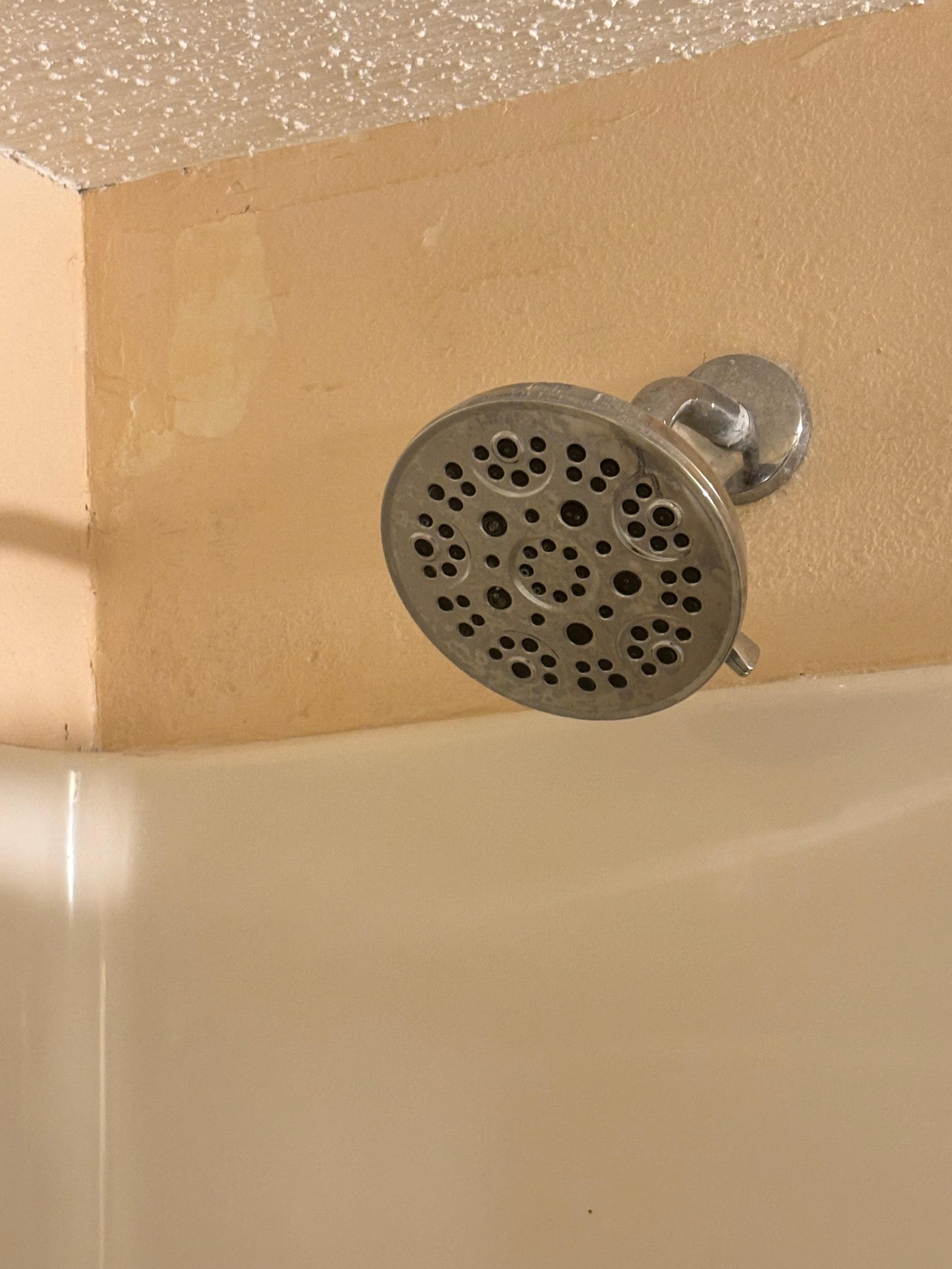 Old shower head and dust on the wall