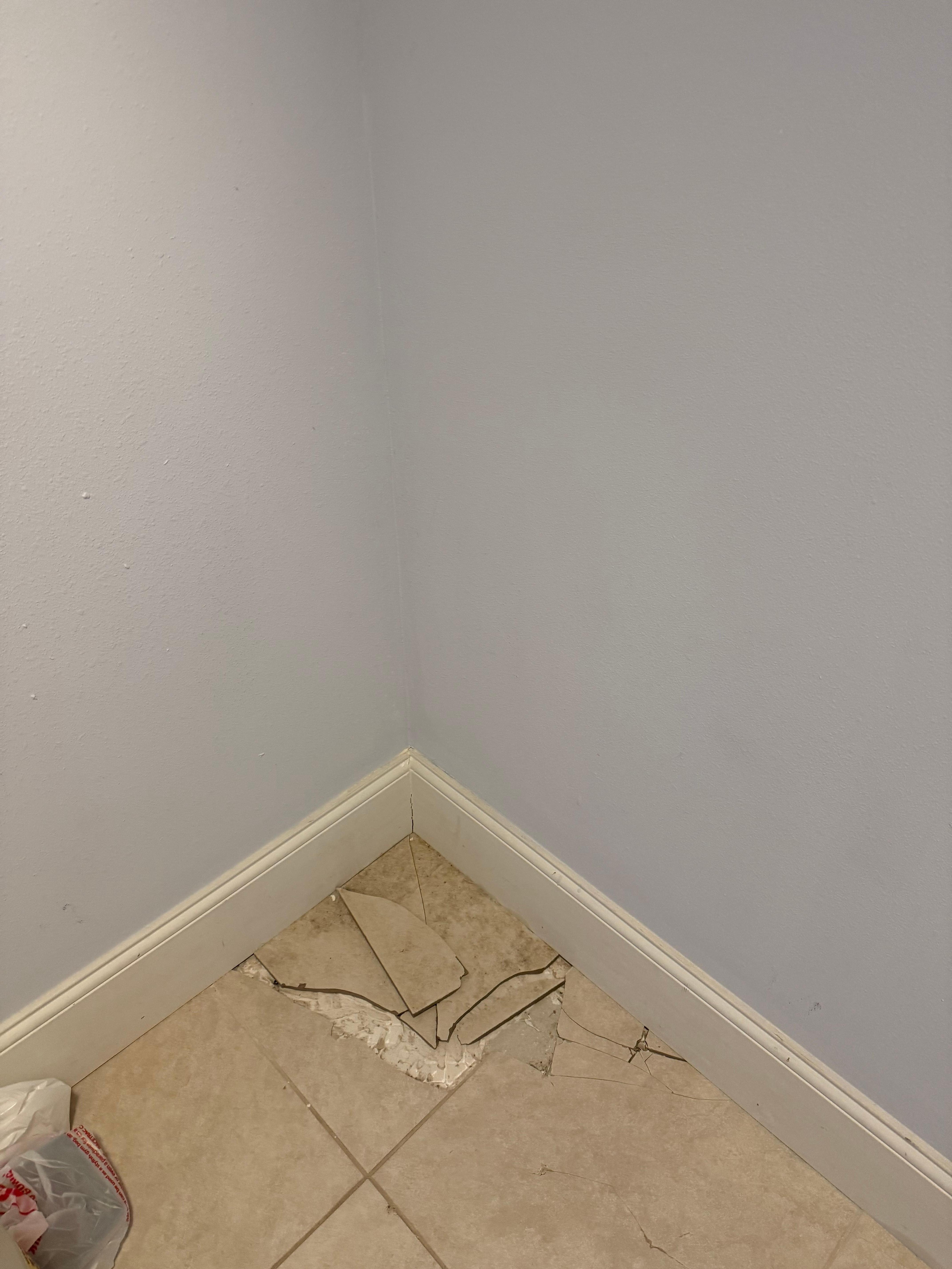Broken tile that was hidden by a mirror in master suite closet
