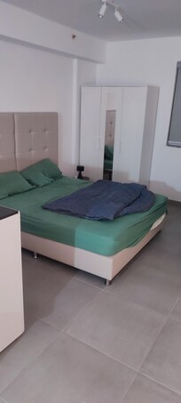 double bed with chest of drawers and a wardrobe (iron, ironing board, drying rack inside)