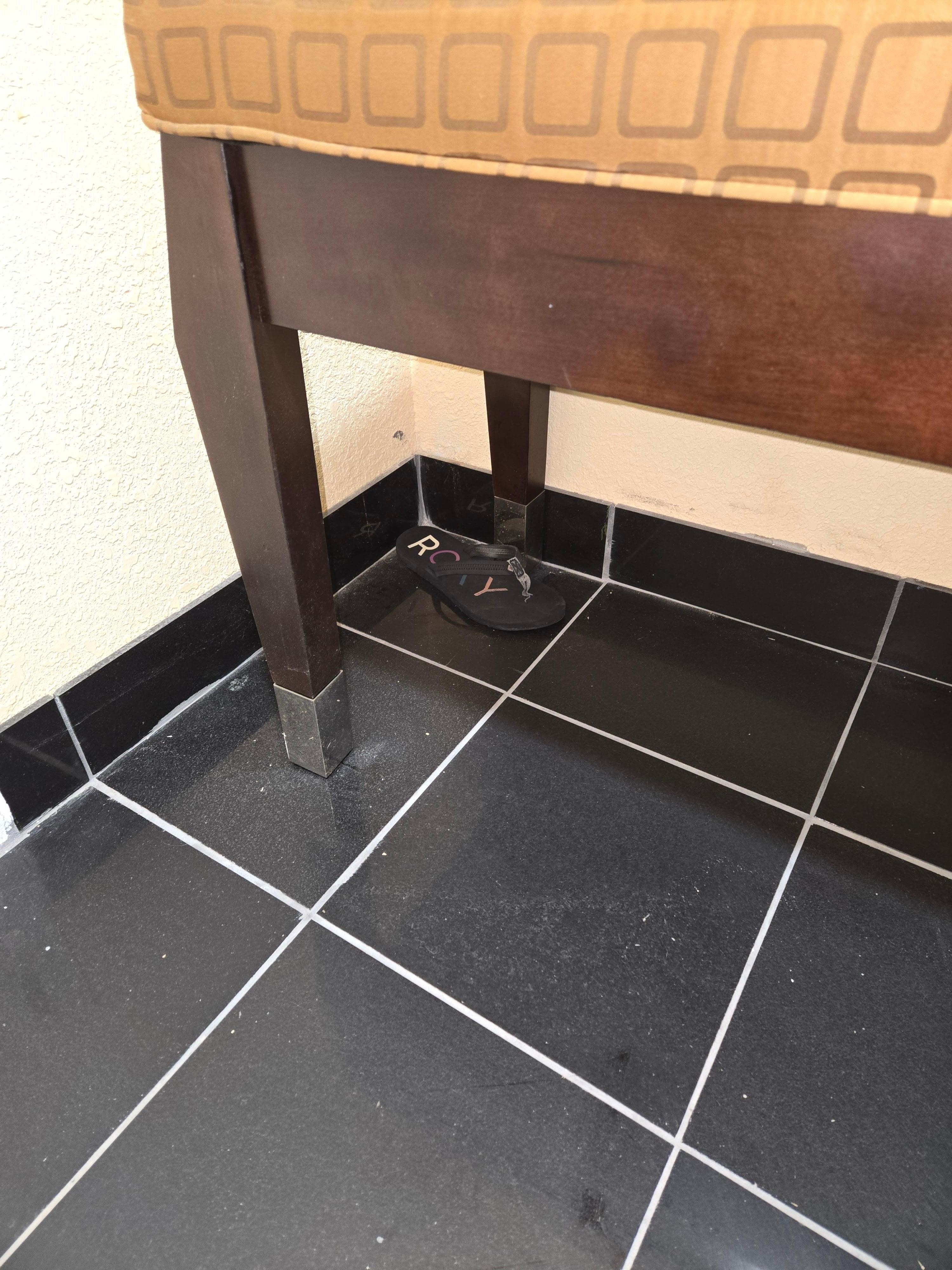 Old dirty shoe under entry bench in the room. 