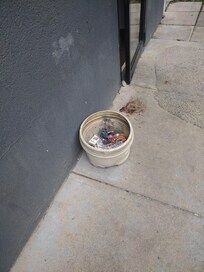 Open door held by rock and possible blood by the bucket.