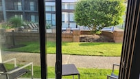 View from room of patio in foreground and enclosed courtyard beyond.