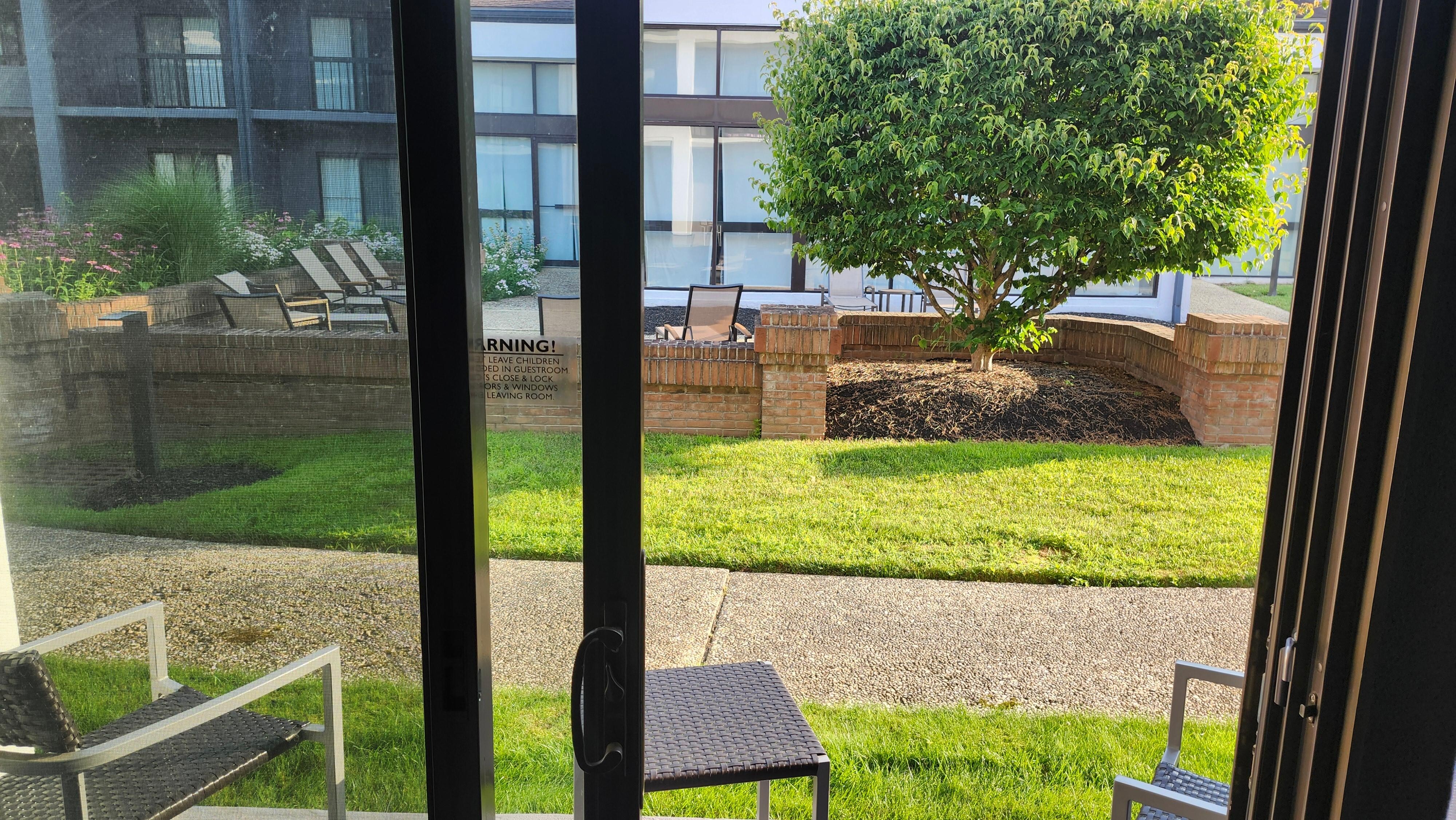 View from room of patio in foreground and enclosed courtyard beyond.