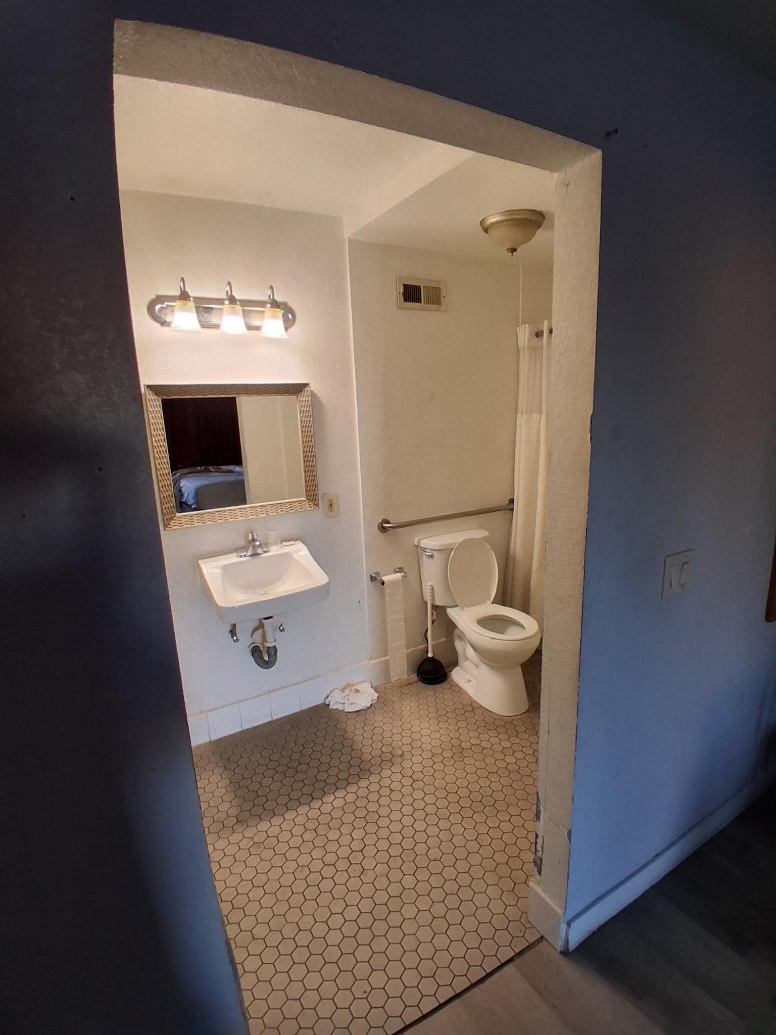 Bathroom view with no Privacy nor a vanity to sit personal items on.