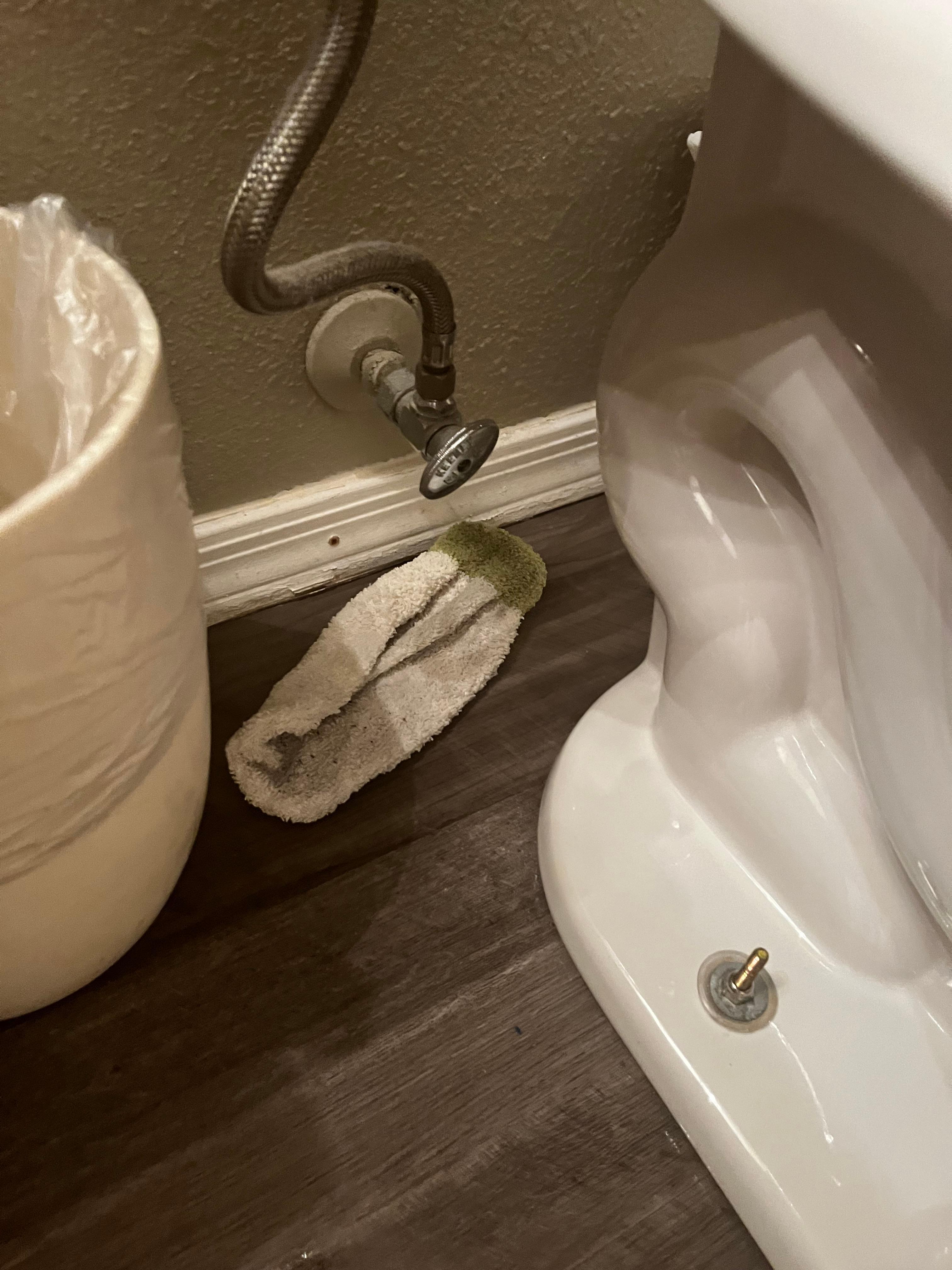 Loose toilet and dirty rag left by cleaners.