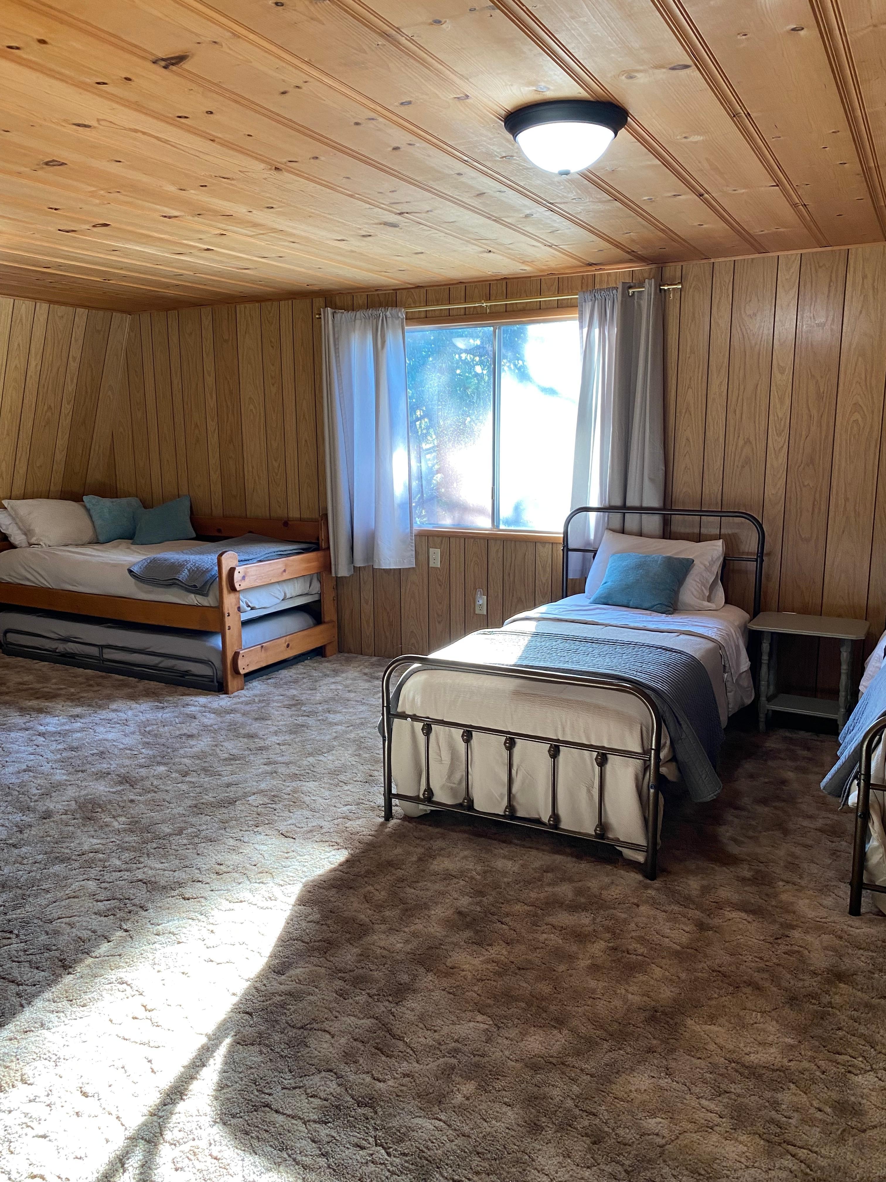 Upstairs loft with multiple beds, it leads out to a patio.