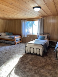 Upstairs loft with multiple beds, it leads out to a patio.