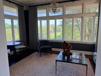 Sitting are with view of garden and city with dining table