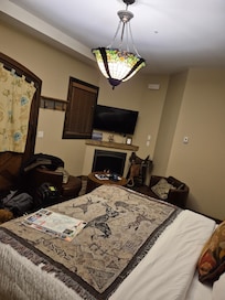 King bed with fireplace and seating area. Views of mountains