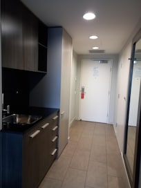 L'entrée, vue de la chambre, et la kitchenette. A gauche après la porte d'entrée, la porte de la salle de bain