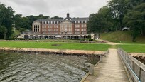 Hotellet ser fra badebroen. Der er mulighed for gode gåture, leg og spil på græsplænen og mange gode siddepladser.