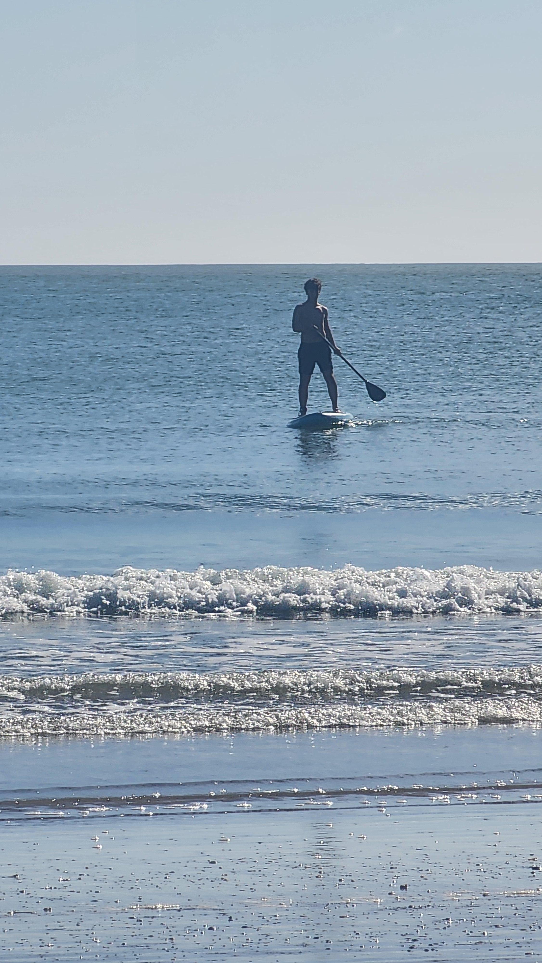 My son using the Paddle Board that was available, on the beach a 2 minute walk from the house.