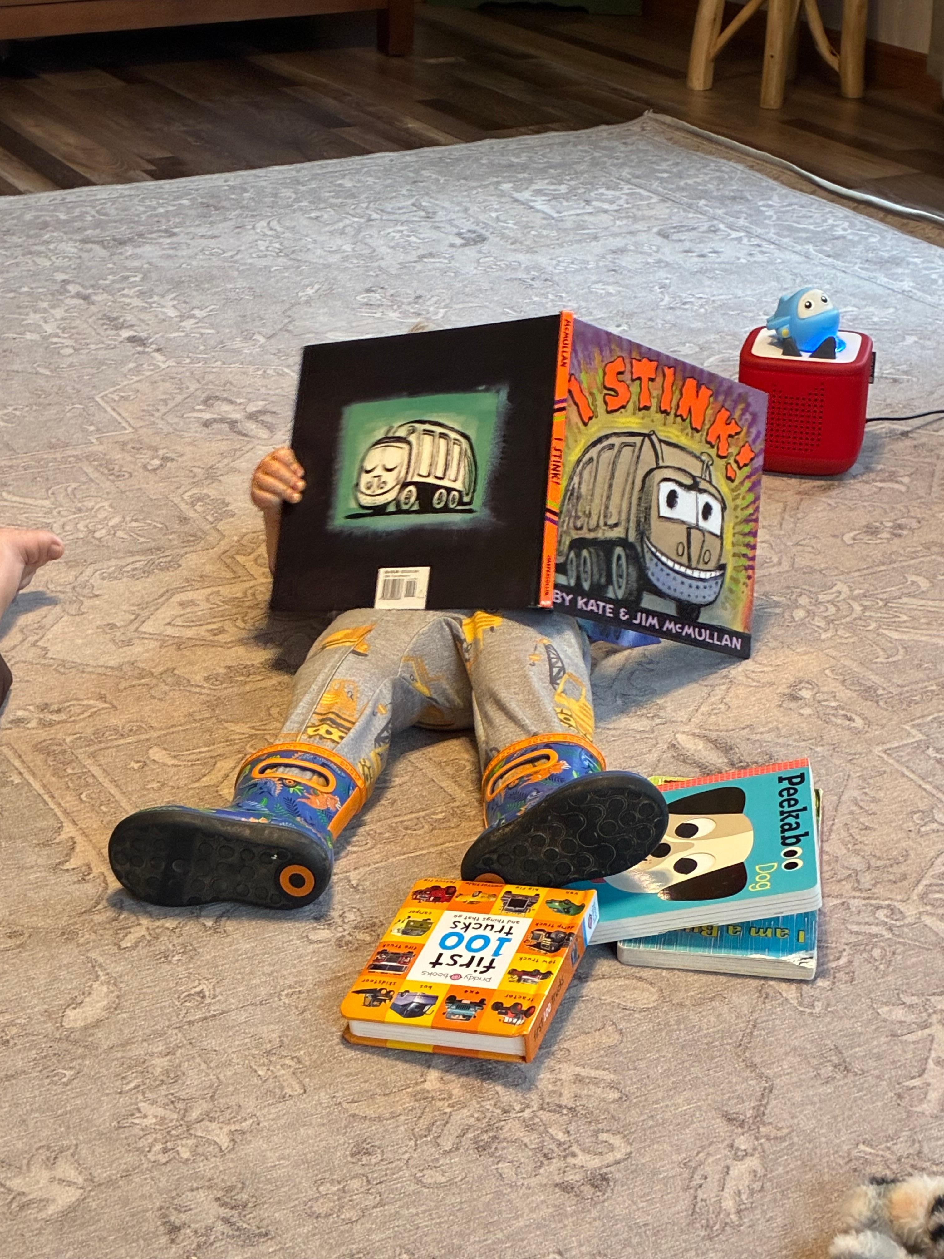 My grandson right at home laying on the livingroom rug reading.