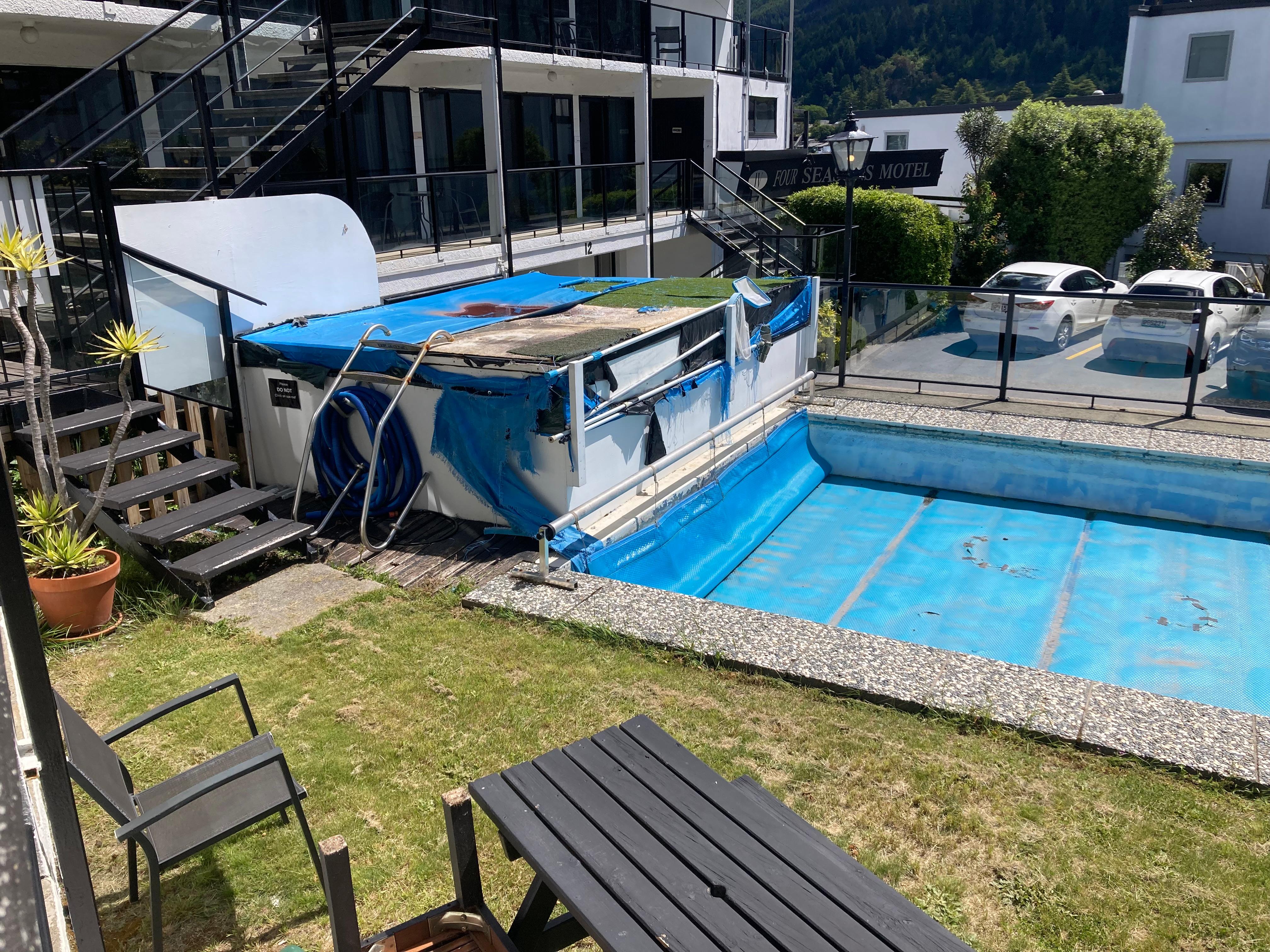 Tatty pool cover and water that has probably been there for years