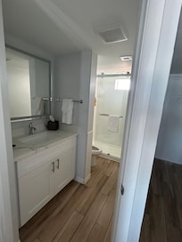 Bathroom standup shower, single vanity, toiletries included (shampoo, conditioner, body wash, hand soap, lotion).