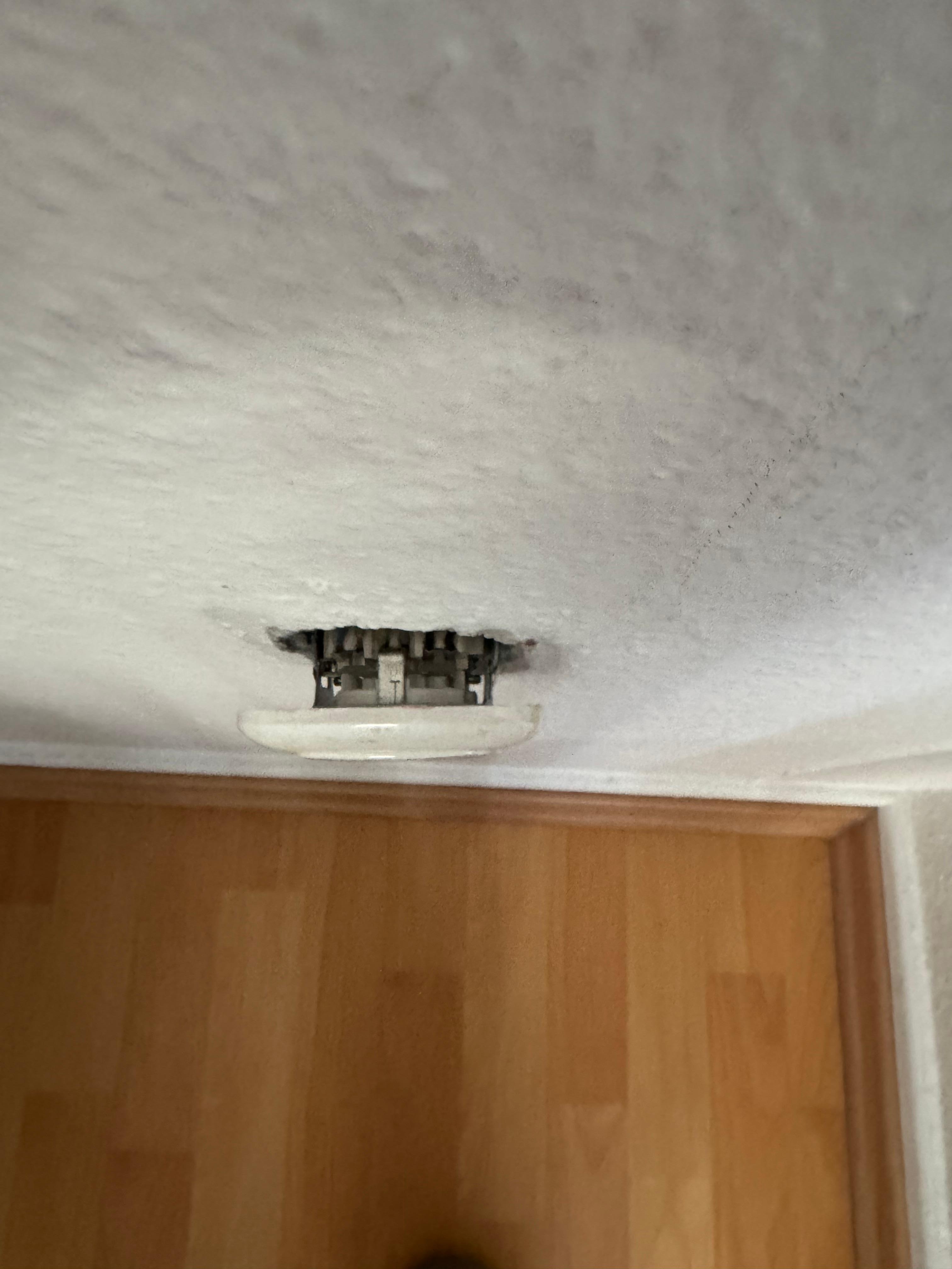 Gefährliche Steckdose mit offenen Kabeln