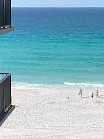 Out our balcony. If you look close you can see dolphins also. Look straight ahead of the people walking on the beach