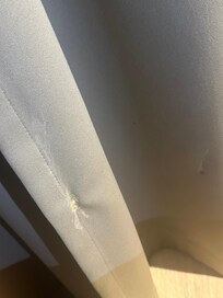 White stain on the curtains next to the bed