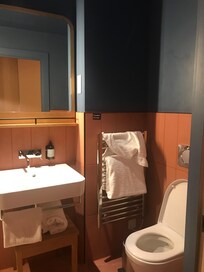 Toalettet med vask, håndklevarmer, og mye håndklær