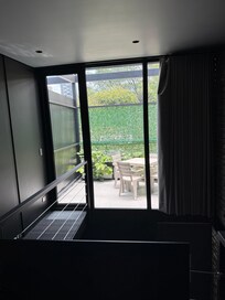 Upstairs bedroom with large screen TV and balcony.