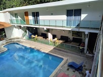 Swimming pool with rooms in background.