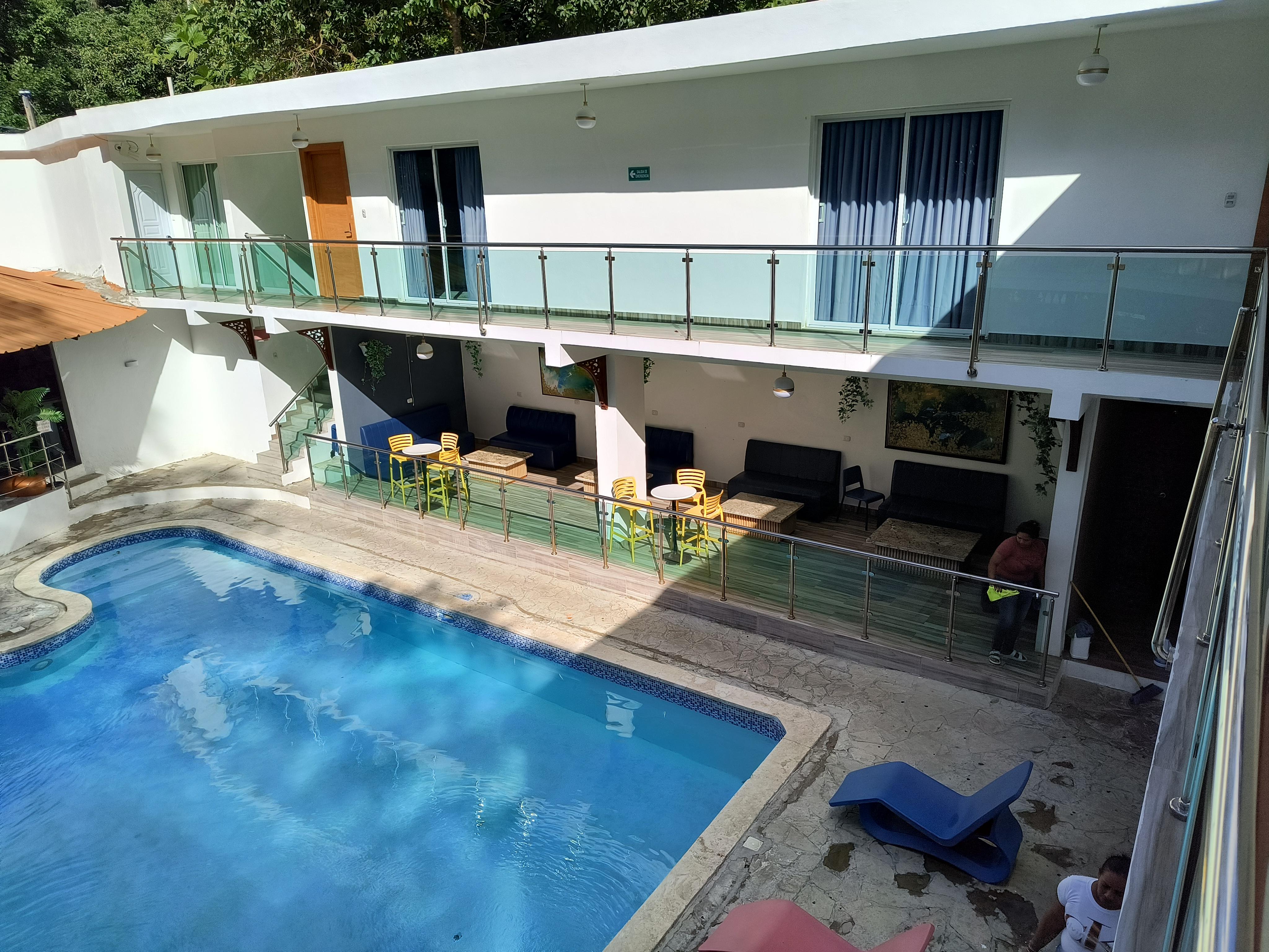 Swimming pool with rooms in background.