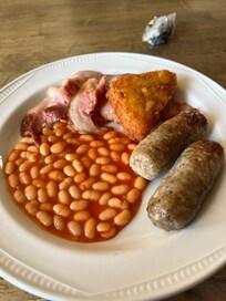 Breakfast comprised of inedible herby sausages, fatty bacon