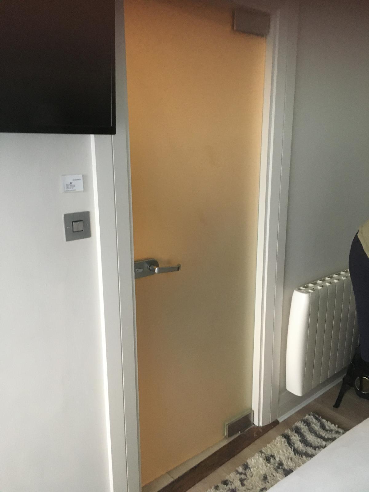 Frosted glass door to shower room hits bed when opened the other way