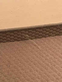 Spinnennetze auf dem Boden, Staub und Bonbonpapier unter dem Bett