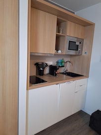 Küchenzeile mit Nespressomaschine, Kühlschrank und Geschirrspülmaschine.