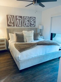 Primary bedroom with darkening shades & a sliding glass door. Bed is so comfy!