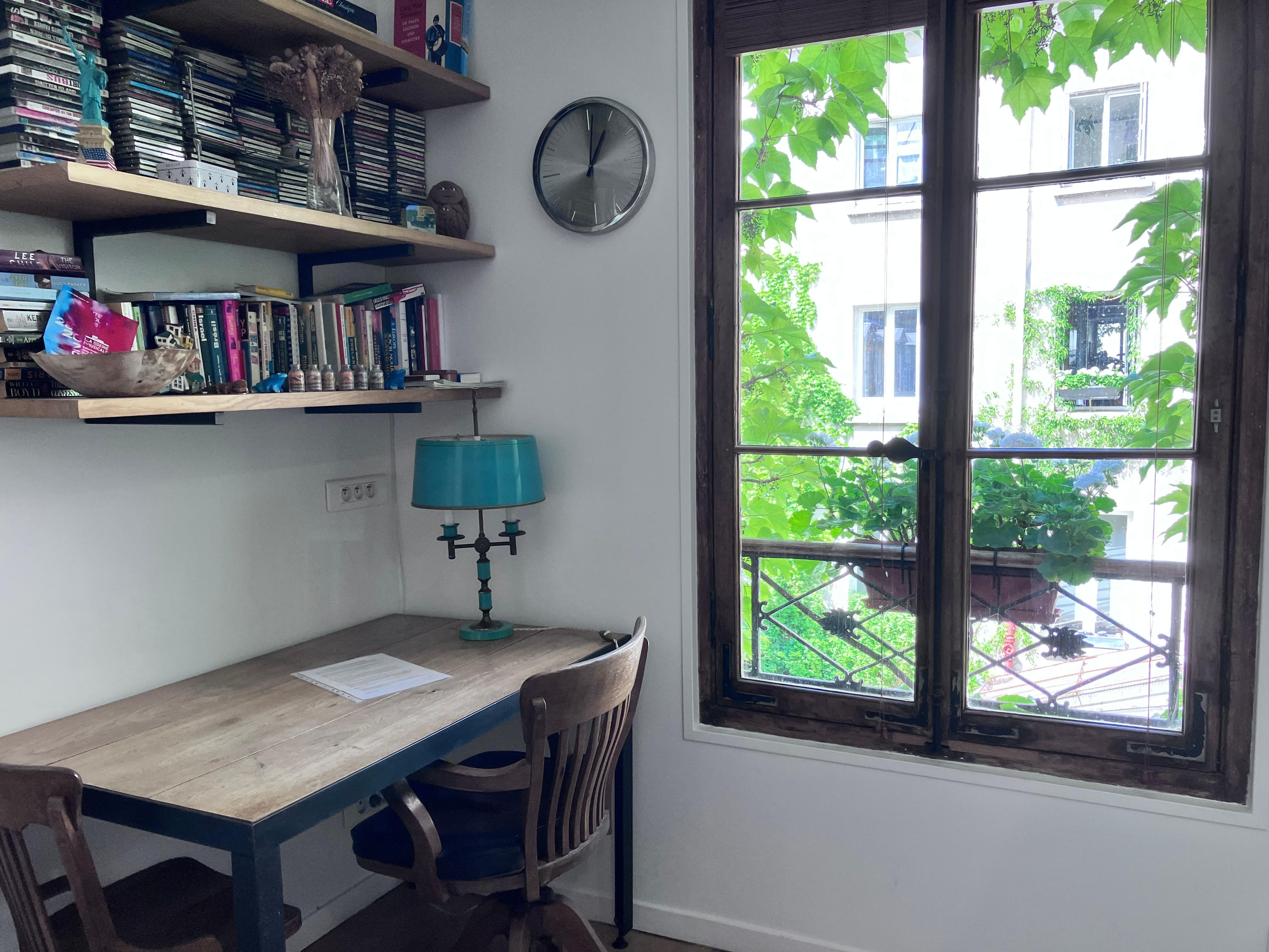 Desk, bookshelf, one of 3 windows into quiet courtyard. 