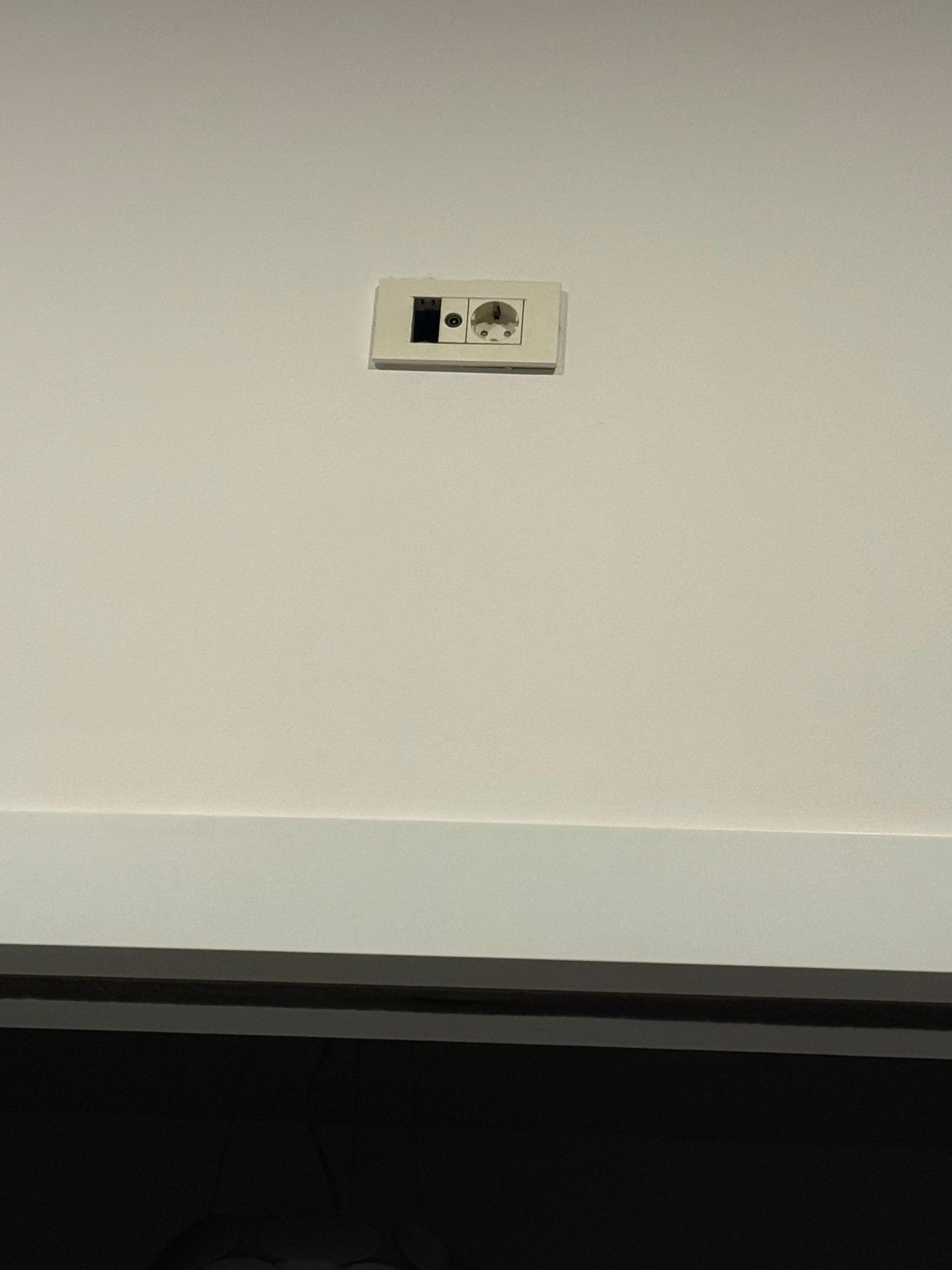 Stikkontakt høyt oppe på veggen. Trodde først det var kamera, men det var nok der tv’n hang tidligere, antenneinngang.
