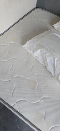 The bed with orange stains