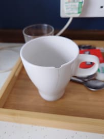 Chipped cup in room for tea and coffee