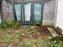 Overgrown patio flagstones and unkept area