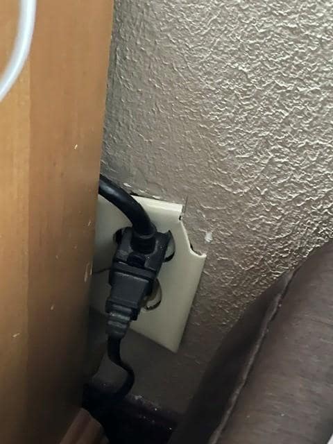 Broken outlet next to bed.