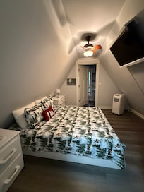 Bedroom with adjoining half bath. The second bedroom is similar, with angle-mounted TV also.