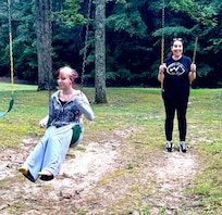 Mother & daughter on swing in backyard