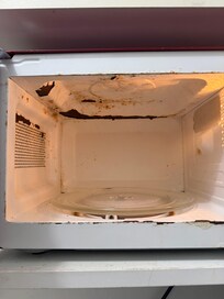 Dirty rusted microwave in room
