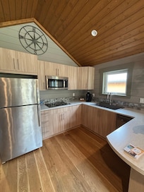 Kitchen with stovetop, microwave, dishwasher! All the dishes and cooking utensils one could need including a wine bottle opener.