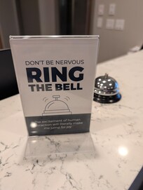 What the sign said after the agent put the bell on the counter.