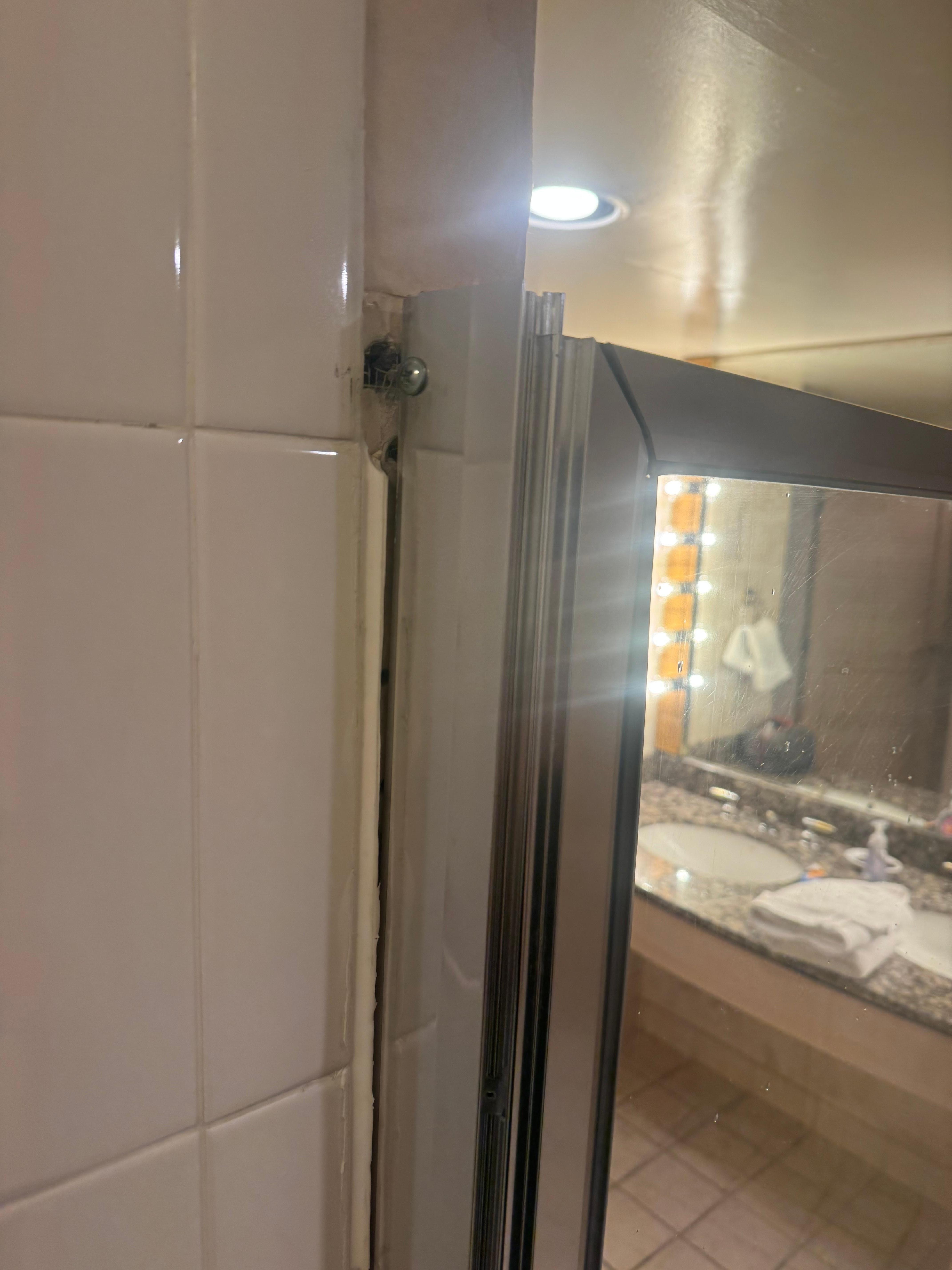 Shower door barely hanging on